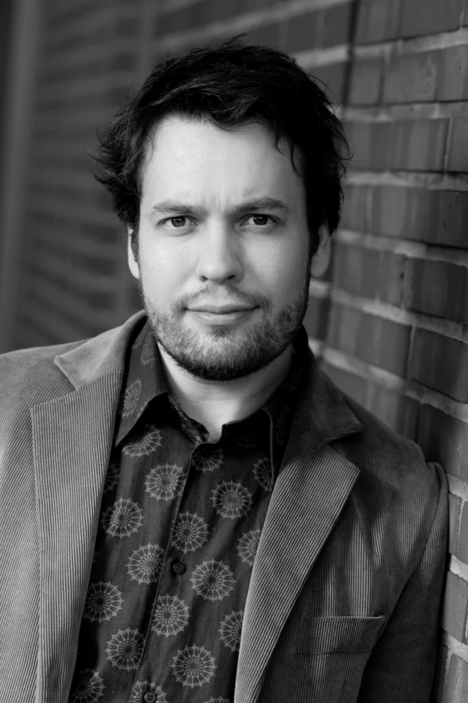 Jonne Valtonen, black and white portrait against a brick wall